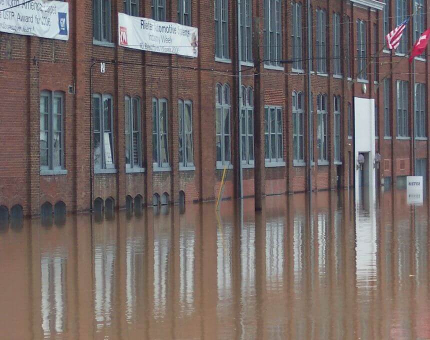 Exterior of the Autoneum plant with floodwater surrounding the building