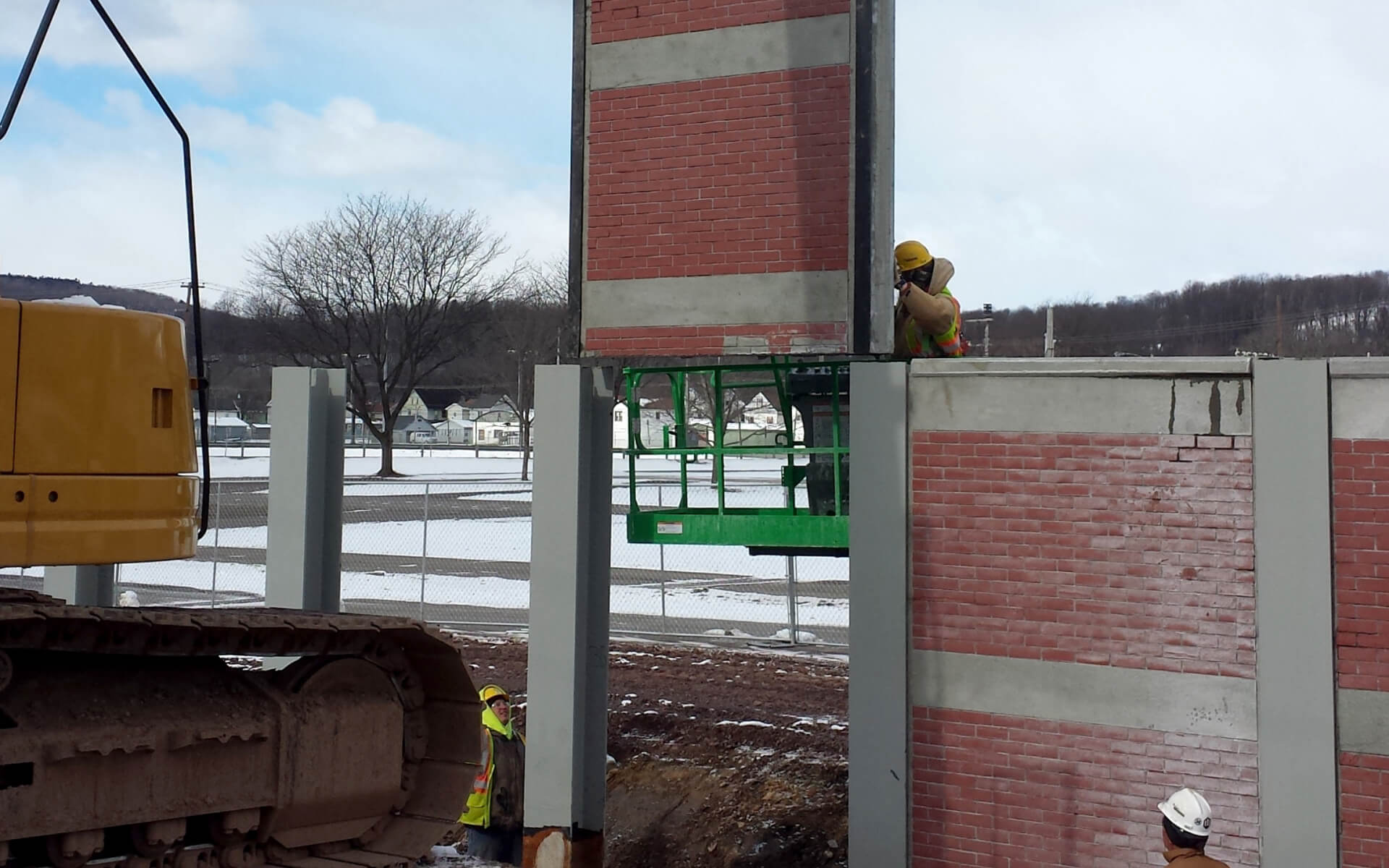 A crane lifts a panel of floodwall into place