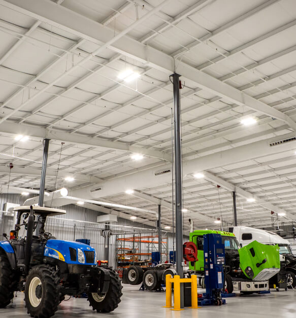 Interior of an Ivy Tech campus building holding tractors, trucks, and other farm equipment