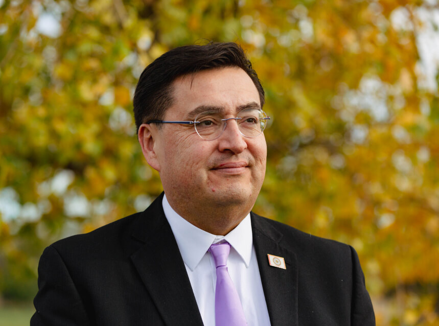 A portrait of Michael LaPointe in front of a tree with yellow leaves