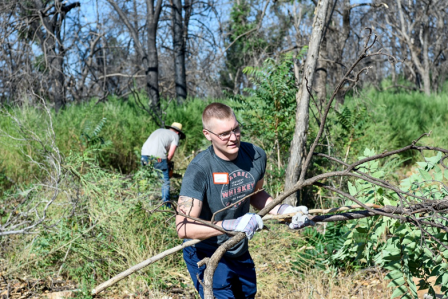An Airman from Beale Air Force Base works to clear branches and brush in 2021 during ongoing recovery efforts in Paradise, California.  