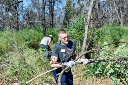 An Airman from Beale Air Force Base works to clear branches and brush in 2021 during ongoing recovery efforts in Paradise, California.