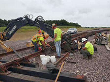 Workers construct new rail spur to facilitate shipping raw materials to manufacturing and distribution center.