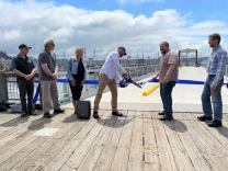 Port of Newport Commission President Jim Burke cuts the ribbon to the newly rebuilt Port Dock 5 Pier.