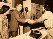 Deputy Assistant Secretary of Commerce for Economic Development Hal Williams greets an attendee at the annual conference of the National Council of La Raza in 1978.