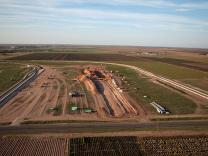 Workers construct new rail spur to facilitate shipping raw materials to manufacturing and distribution center.